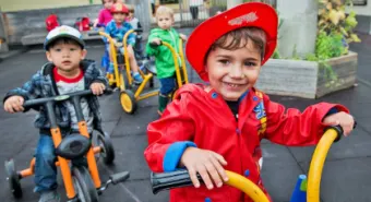 toddlers riding tricycles at YMCA Licensed Care program