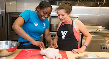 Two girls preparing chicken