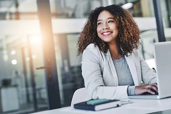 a black woman smiling in front of a computer