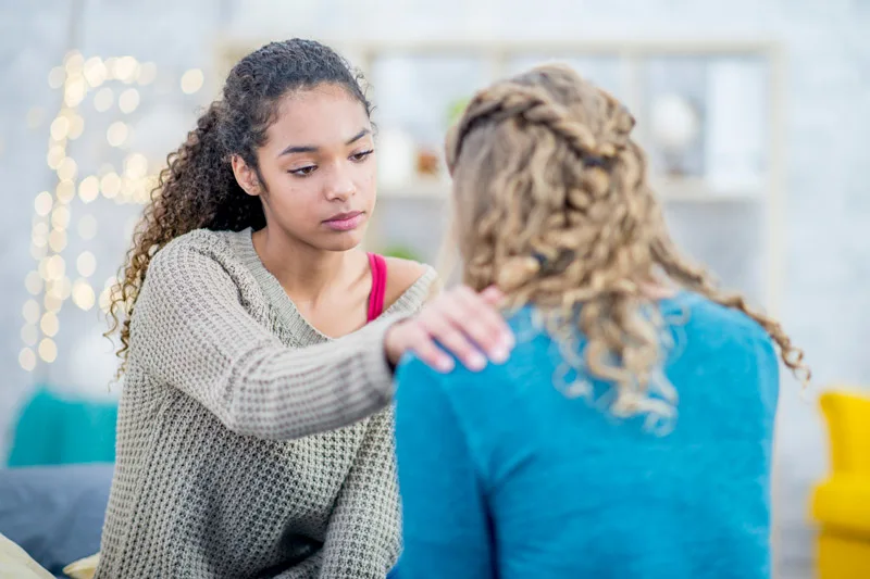 A teenage girl supporting a friend