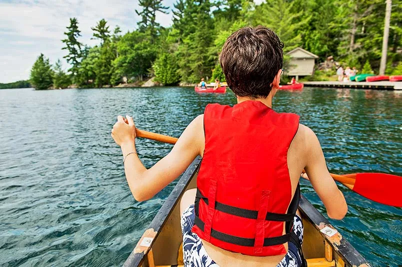 Boy rowing on canoe